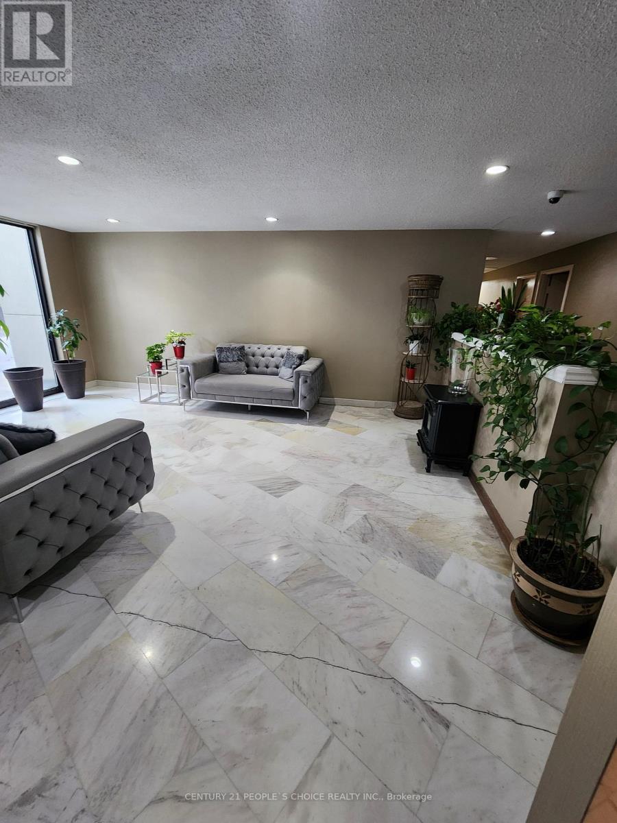 A living room with a grey couch and a marble floor.