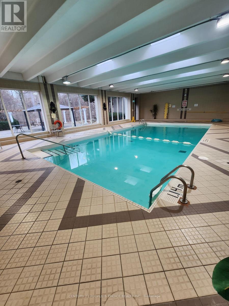 A large indoor swimming pool with a glass enclosure.