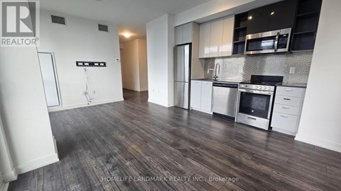 A kitchen with white cabinets and a wooden floor.