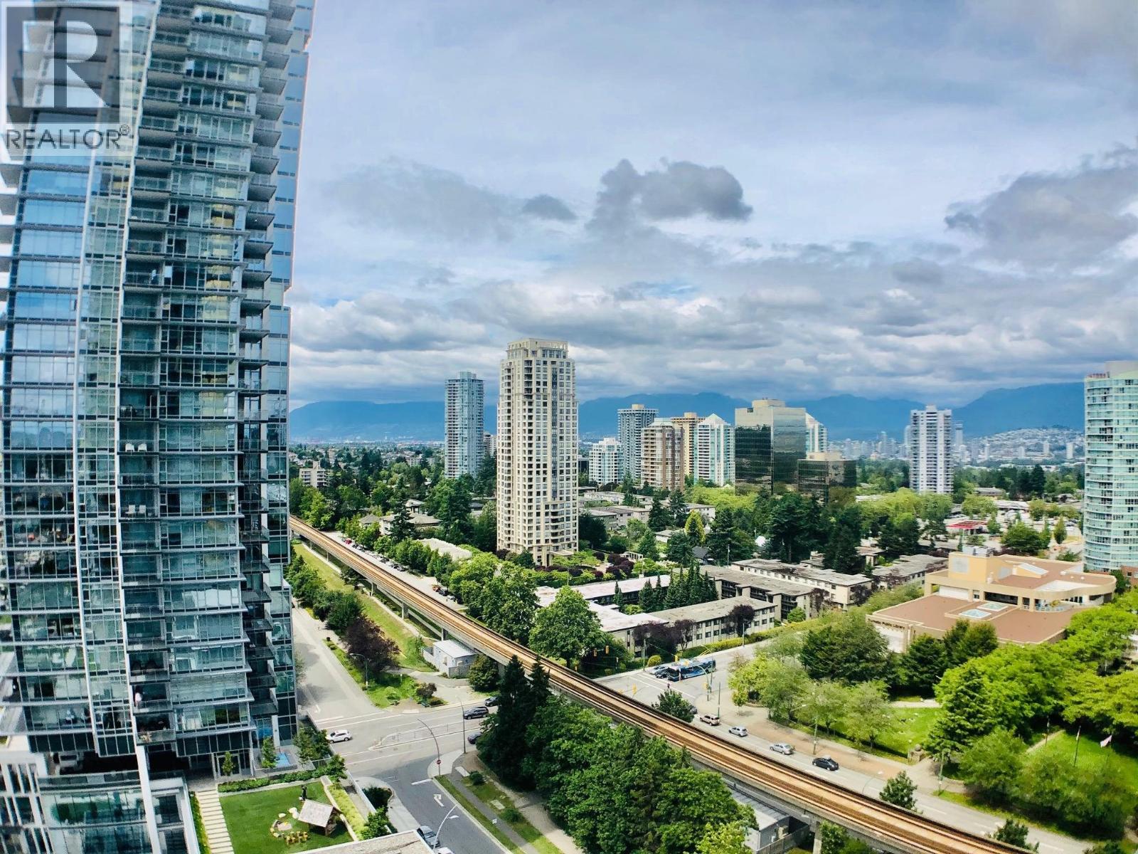 A cityscape with a tall building on the left and a highway in the foreground.
