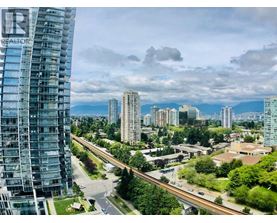 A cityscape with a tall building on the left and a highway in the foreground.
