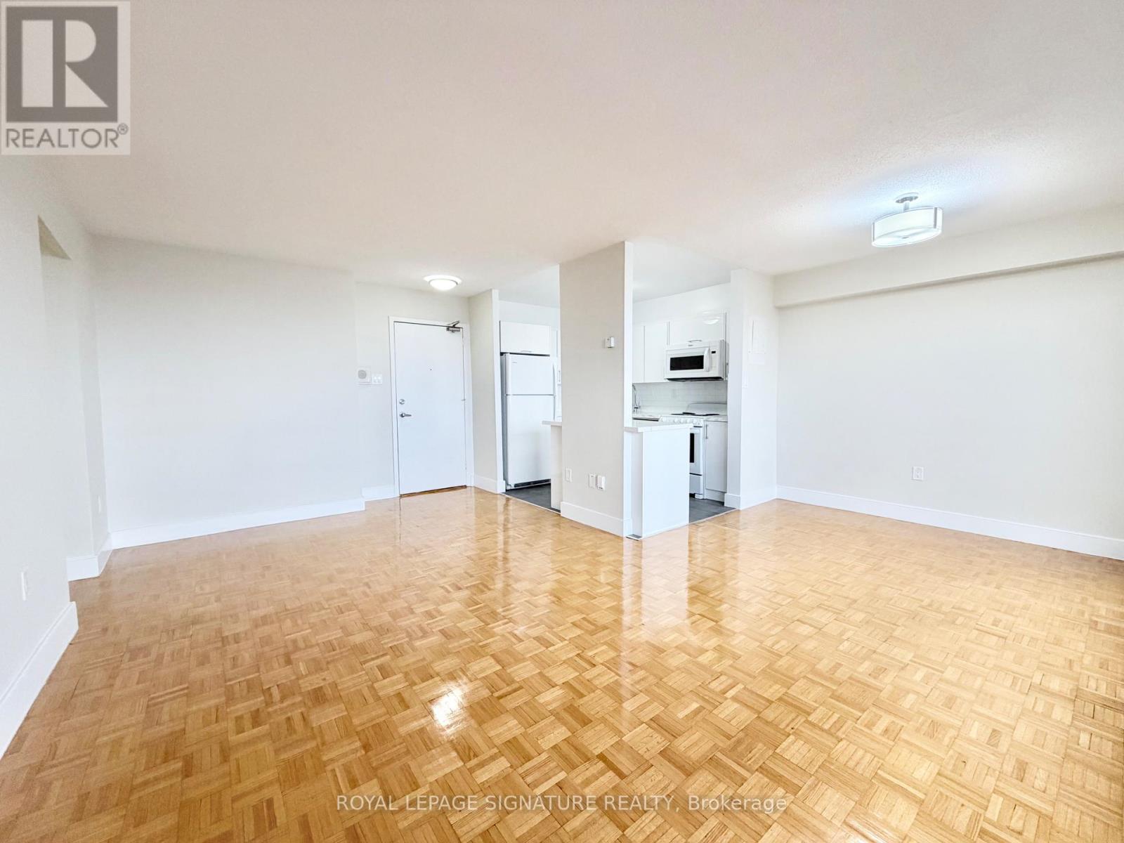 A room with wooden flooring and white walls.