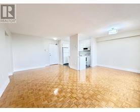 A room with wooden flooring and white walls.