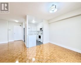 A kitchen with white appliances and wooden floors.