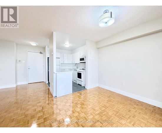 A kitchen with white appliances and wooden floors.