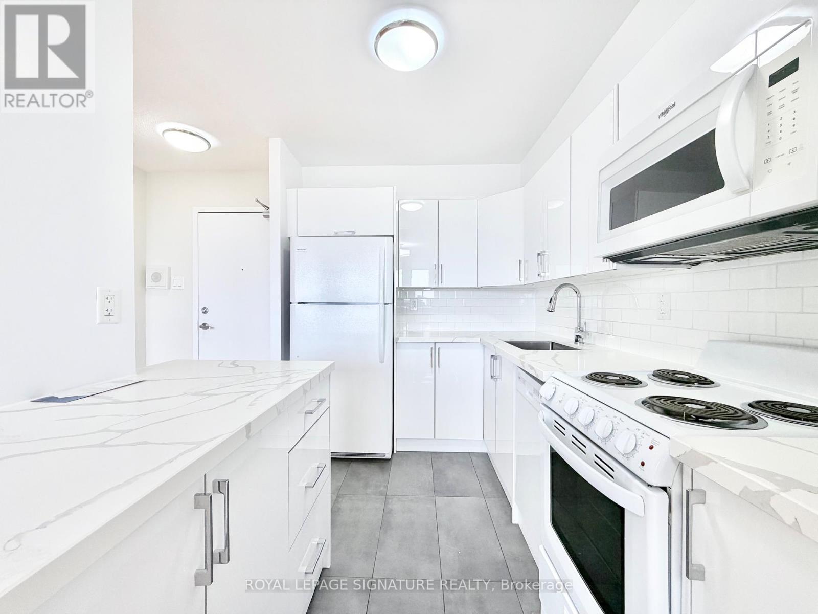 A white kitchen with a stove top oven and a microwave above it.