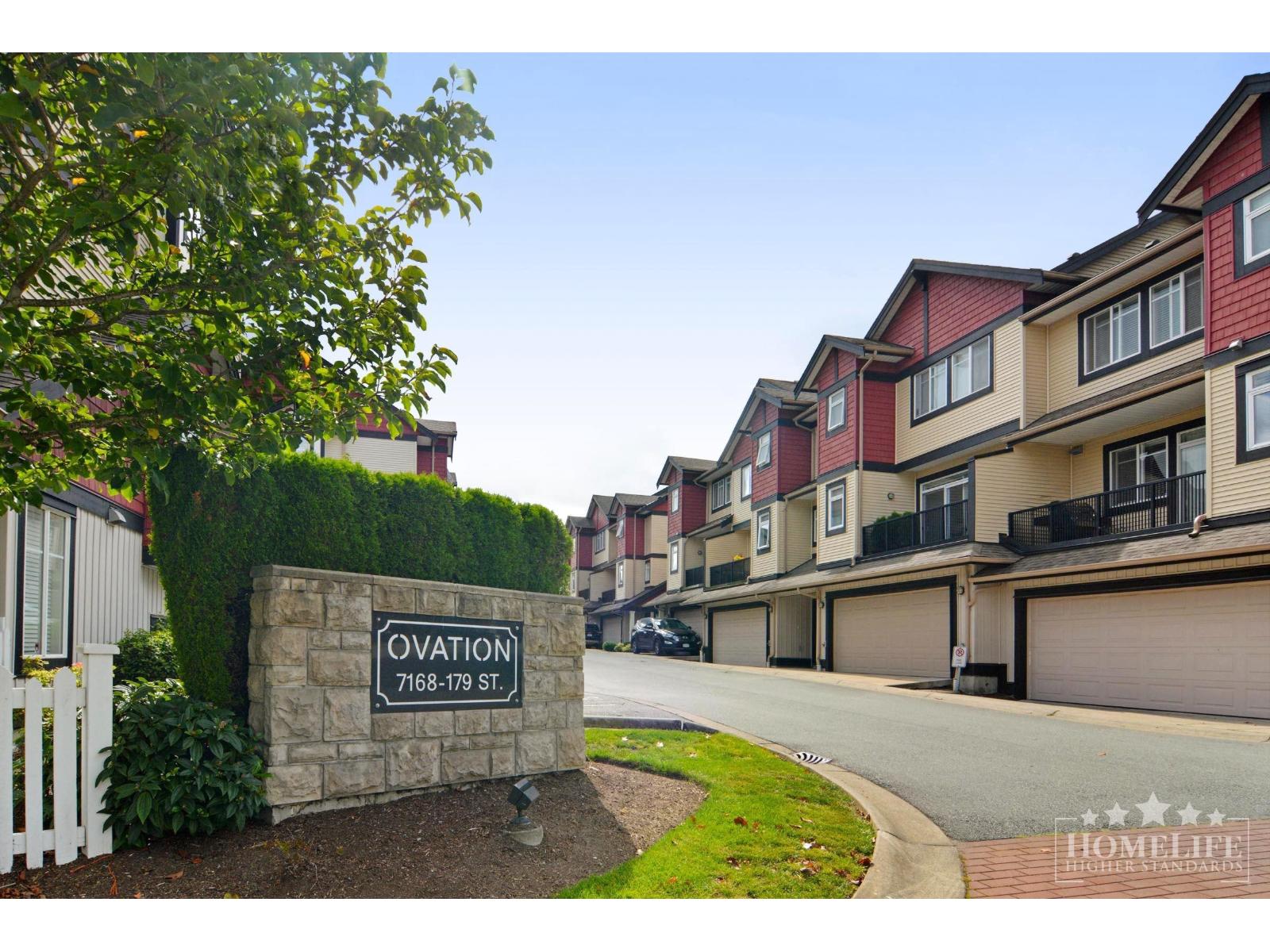A street view of a residential area with a sign that reads "Ovation 7168-179 ST".