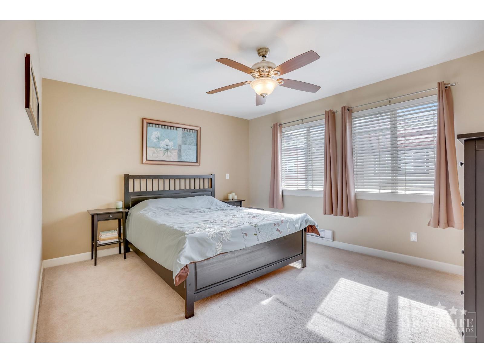 A bedroom with a bed, nightstand, and window.