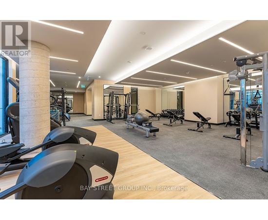 A gym with a variety of equipment including treadmills, weights, and exercise machines.
