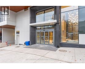 The entrance to a building with a glass door and a sign above it.