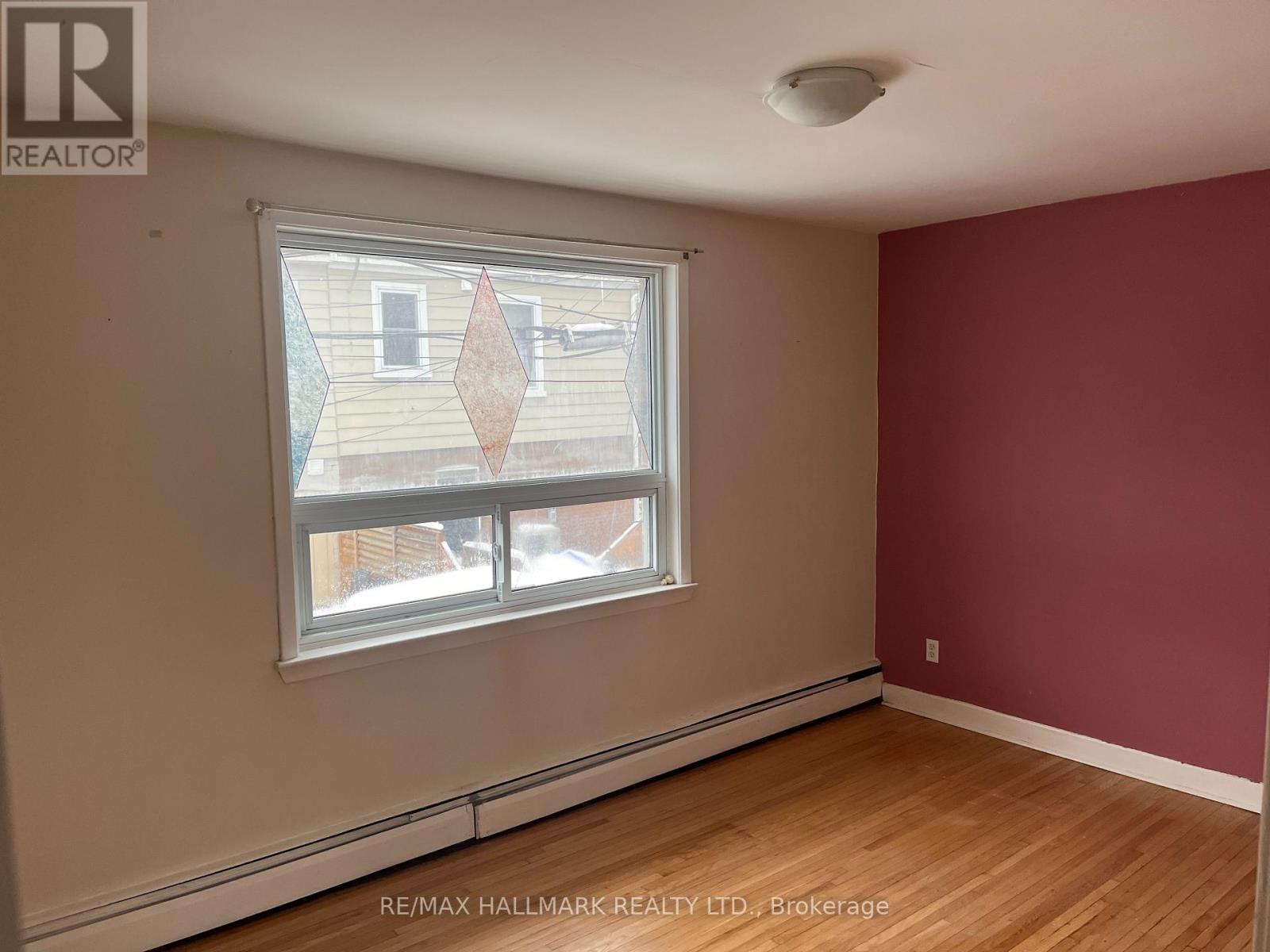 A room with a window showing a view of a building outside.