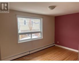 A room with a window showing a view of a building outside.