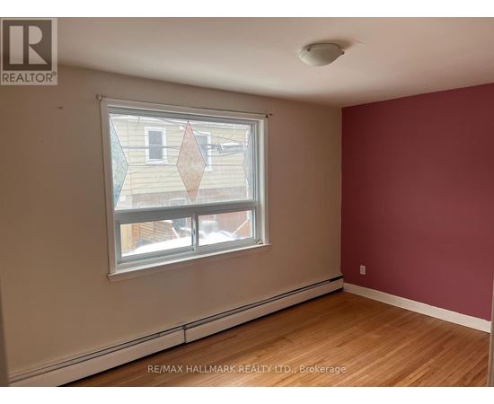 A room with a window showing a view of a building outside.