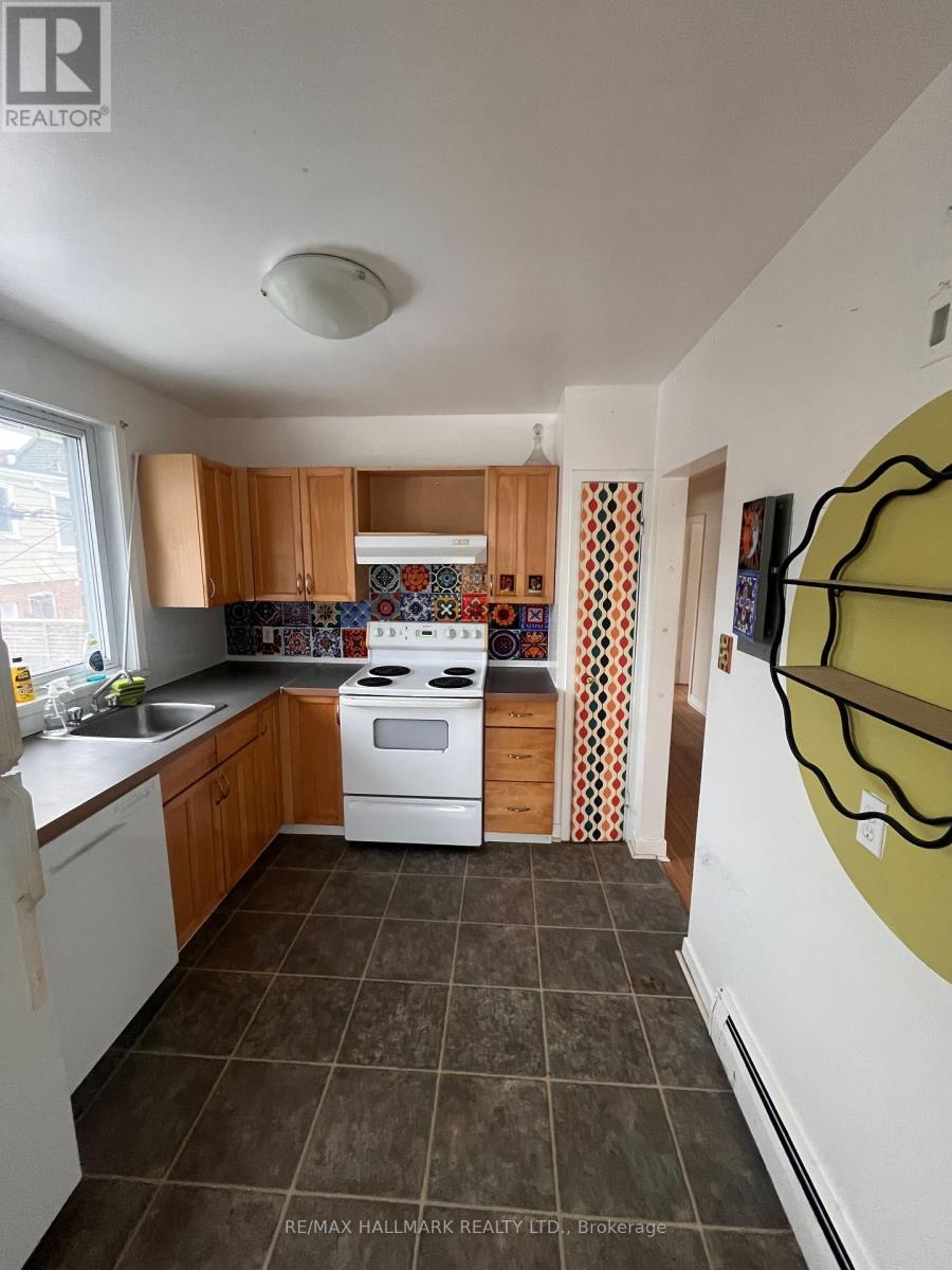 A kitchen with white appliances and brown cabinets.