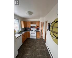 A kitchen with white appliances and brown cabinets.