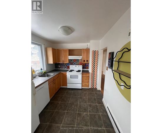 A kitchen with white appliances and brown cabinets.