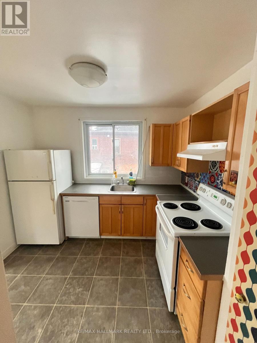 A kitchen with a white refrigerator, white stove, and wooden cabinets.