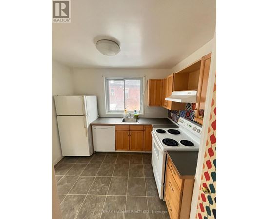 A kitchen with a white refrigerator, white stove, and wooden cabinets.