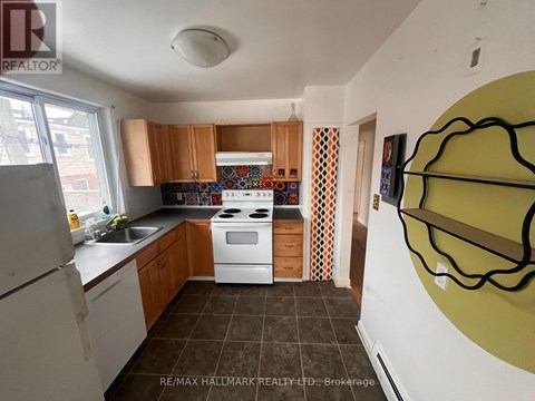 A kitchen with a white stove top oven and white refrigerator.