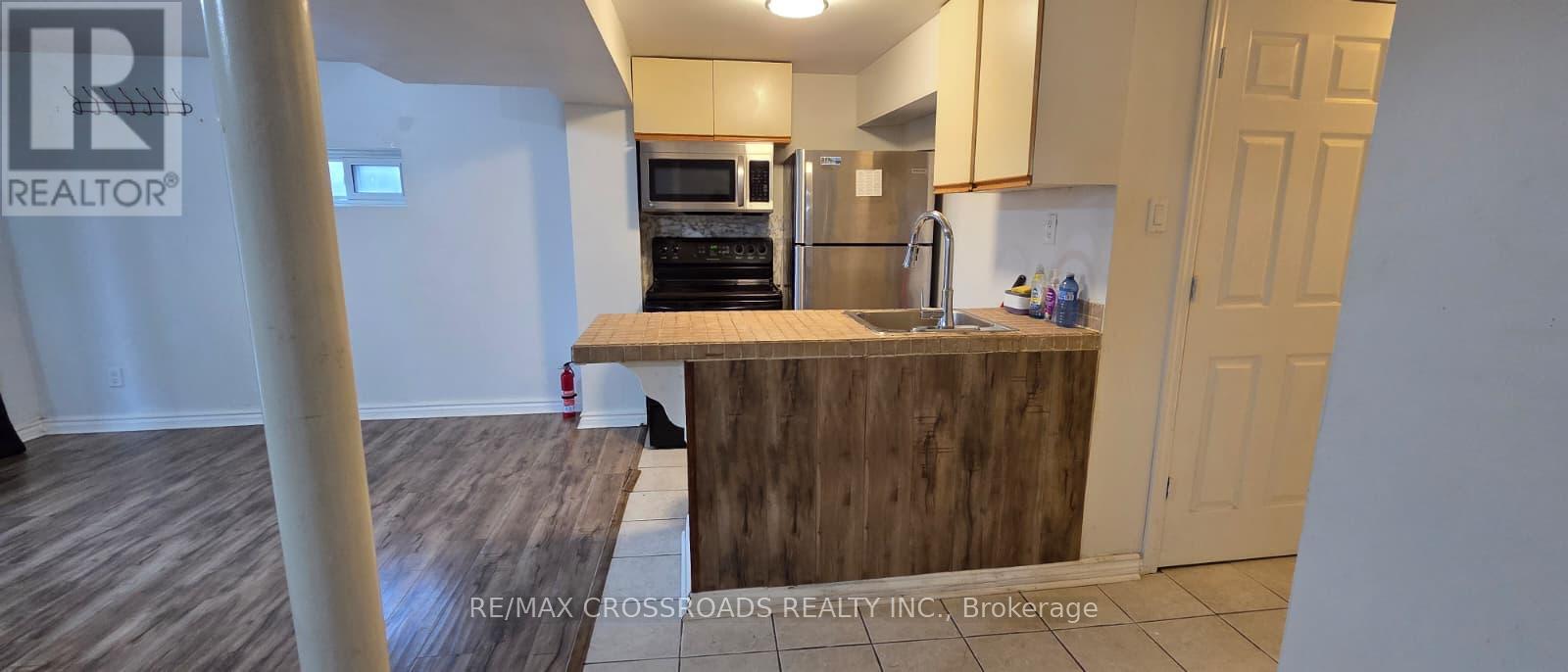 A kitchen with a wooden counter and a refrigerator.