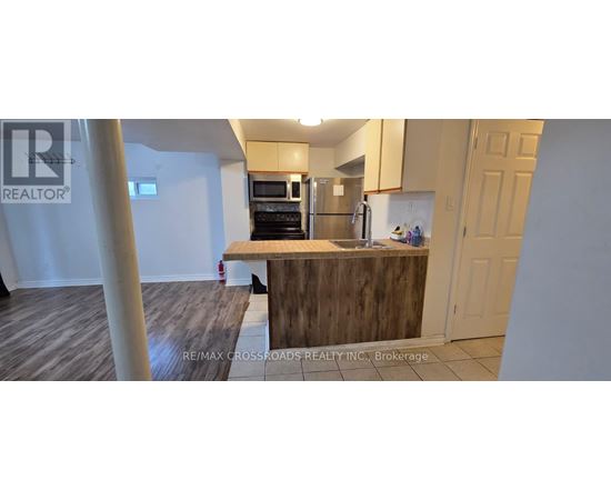 A kitchen with a wooden counter and a refrigerator.