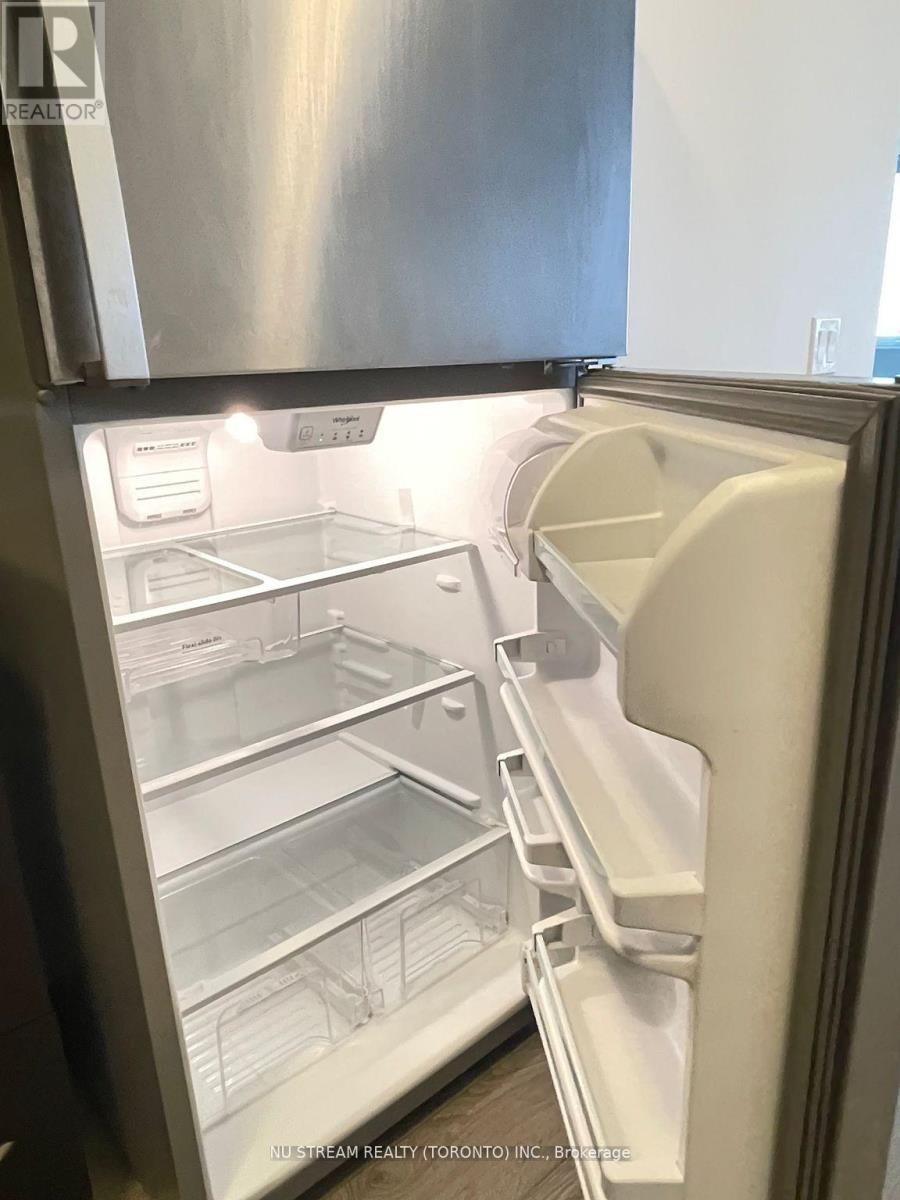 A stainless steel refrigerator with its door open and shelves visible.