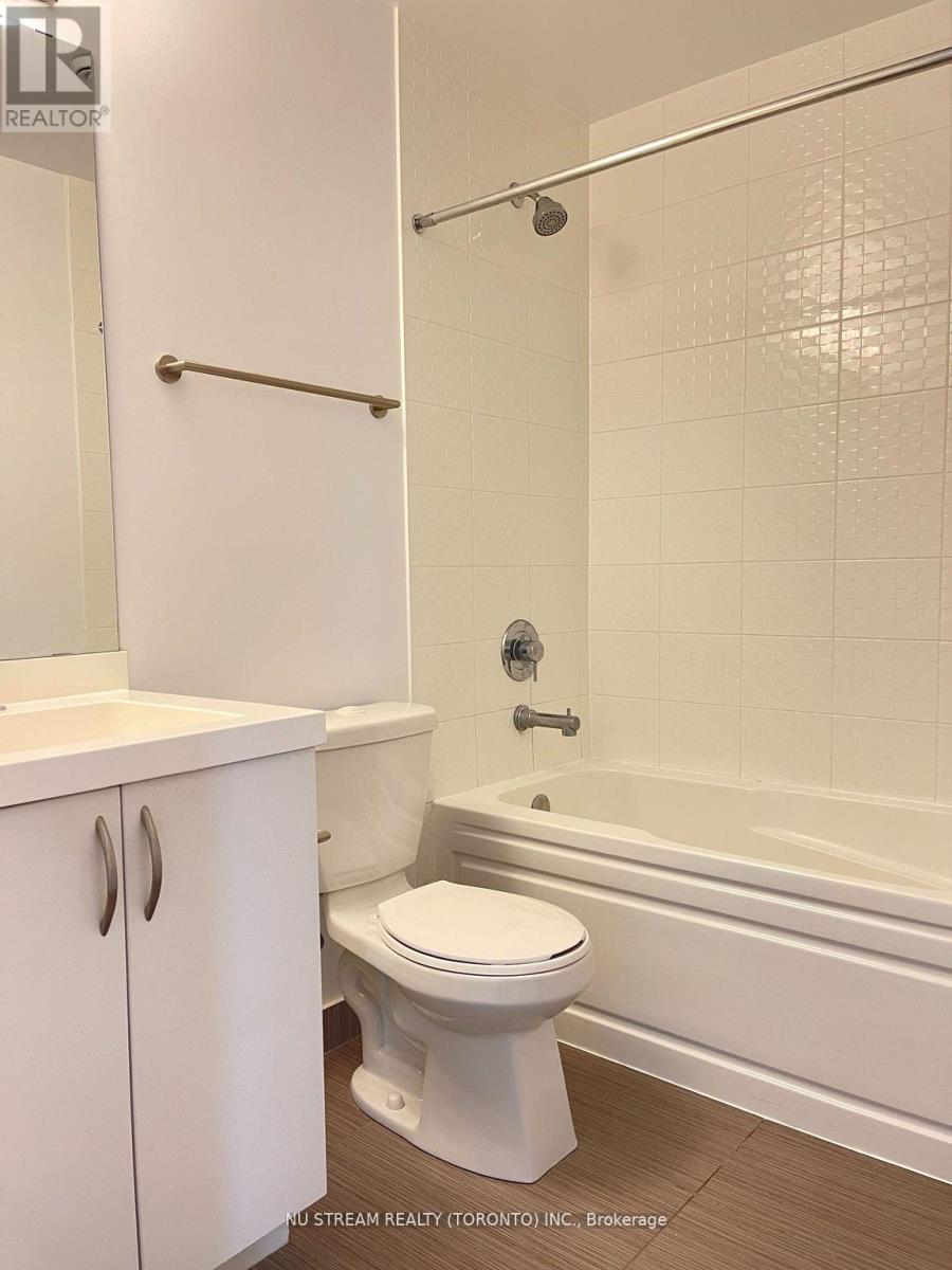 A white toilet sits next to a bathtub in a bathroom.