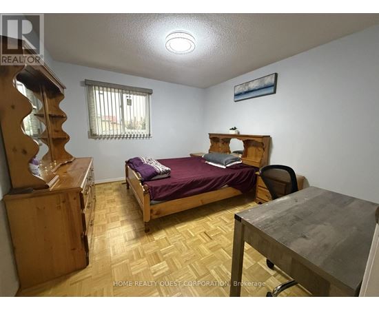 A bedroom with a bed, desk, and chair.