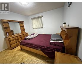 A bedroom with a bed, dresser, and mirror.