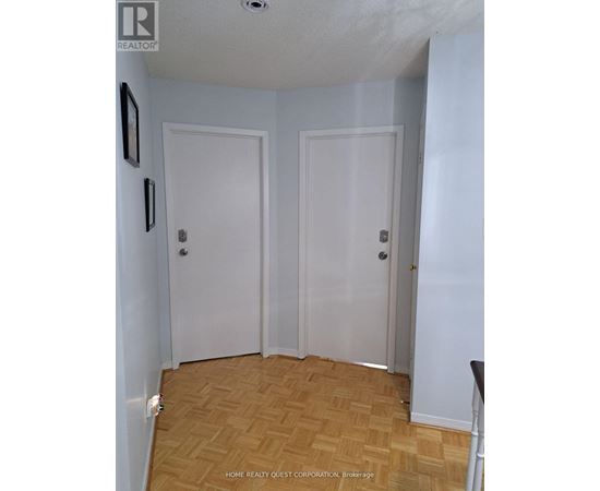 A room with two white doors and a wooden floor.