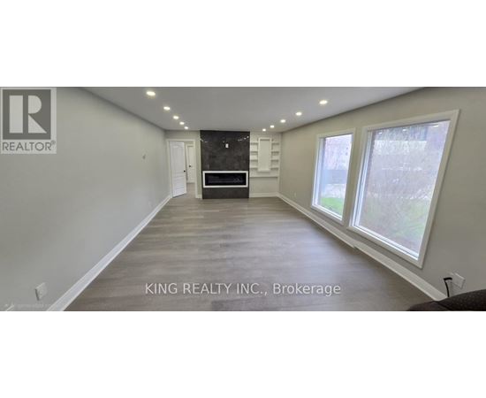 A spacious room with a large window and a door in the background.