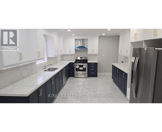 A modern kitchen with a refrigerator on the right and cabinets in white and dark blue.