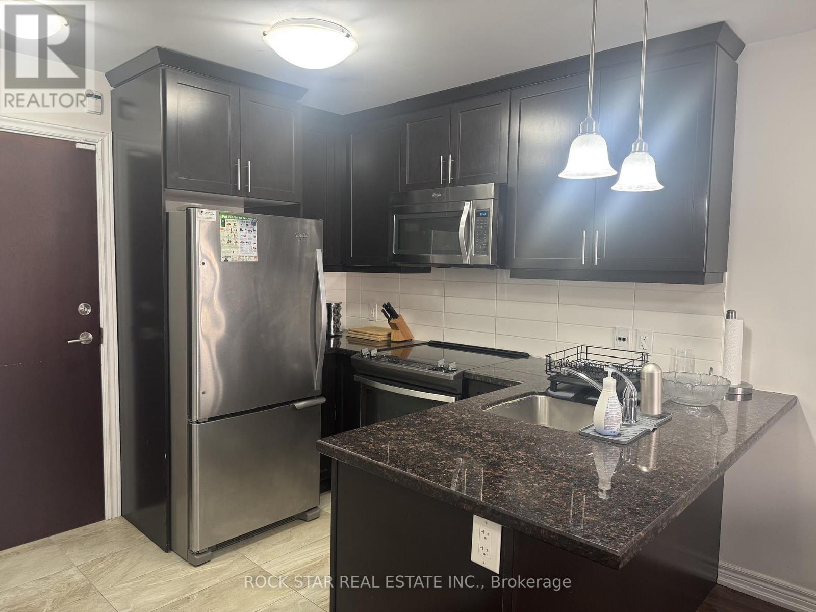 A kitchen with granite countertops and stainless steel appliances.
