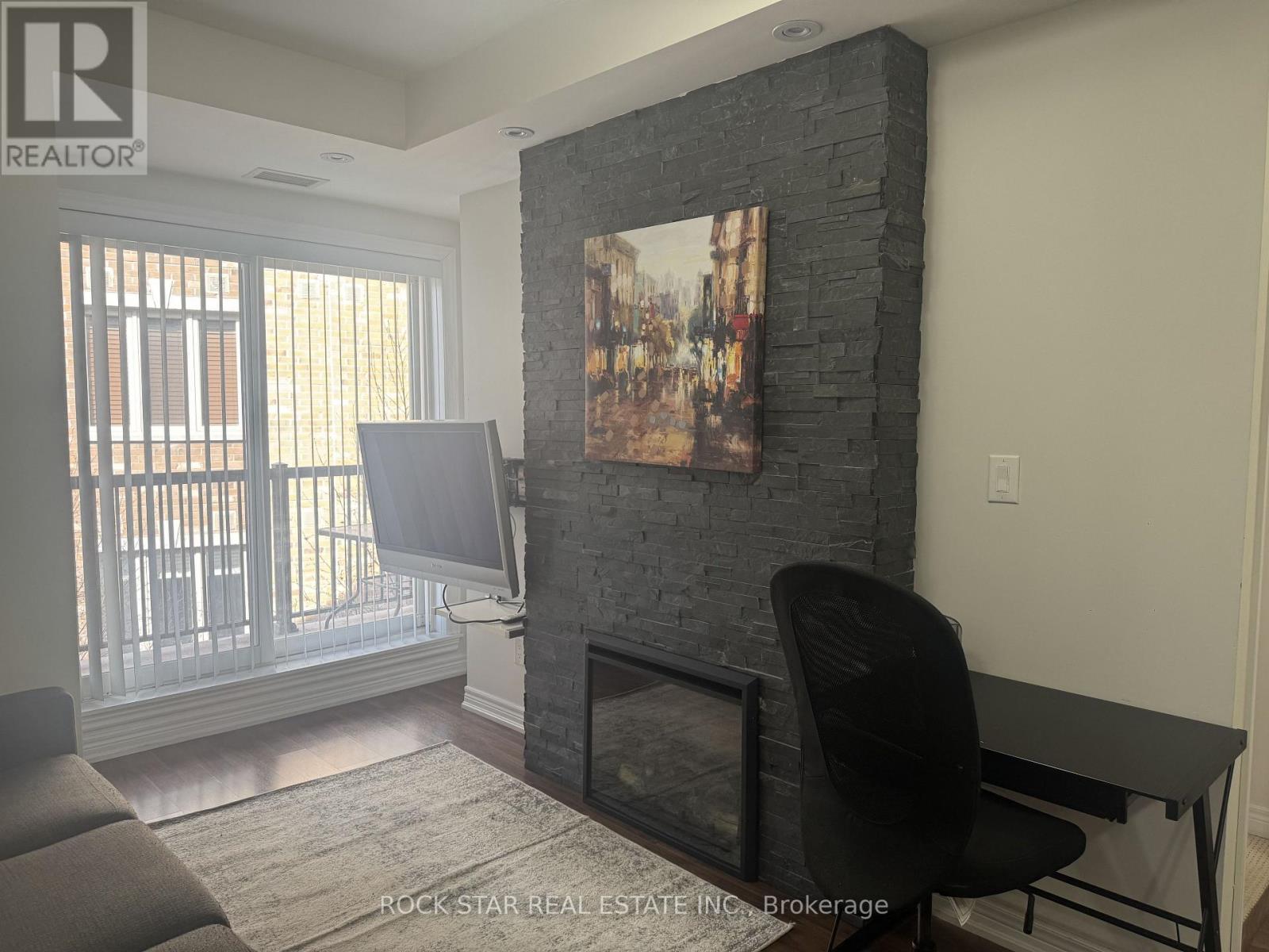 A living room with a fireplace and a painting on the wall.