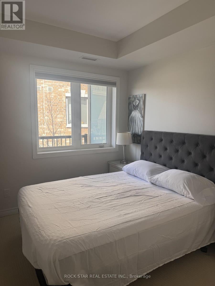 A bedroom with a large bed and a window overlooking a balcony.