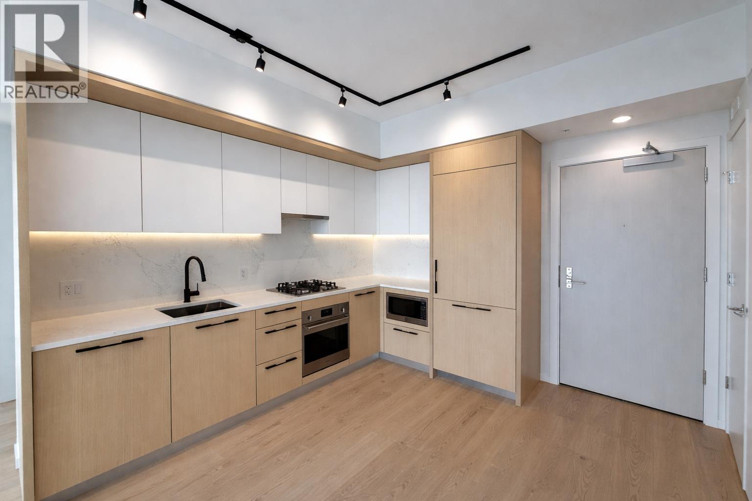 A modern kitchen with wooden floors and cabinets.