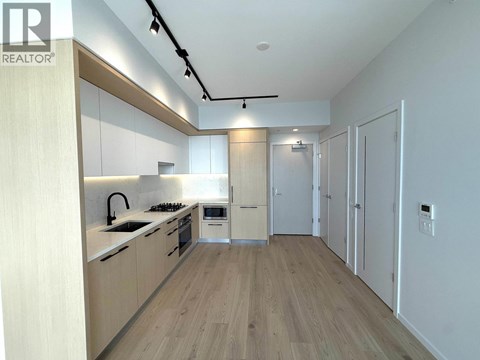 A modern kitchen with wooden cabinets and a white backsplash.