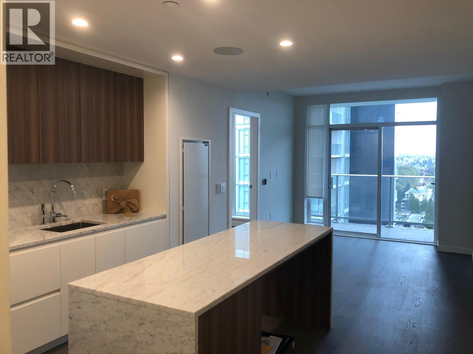 A kitchen with a marble countertop and a sink.
