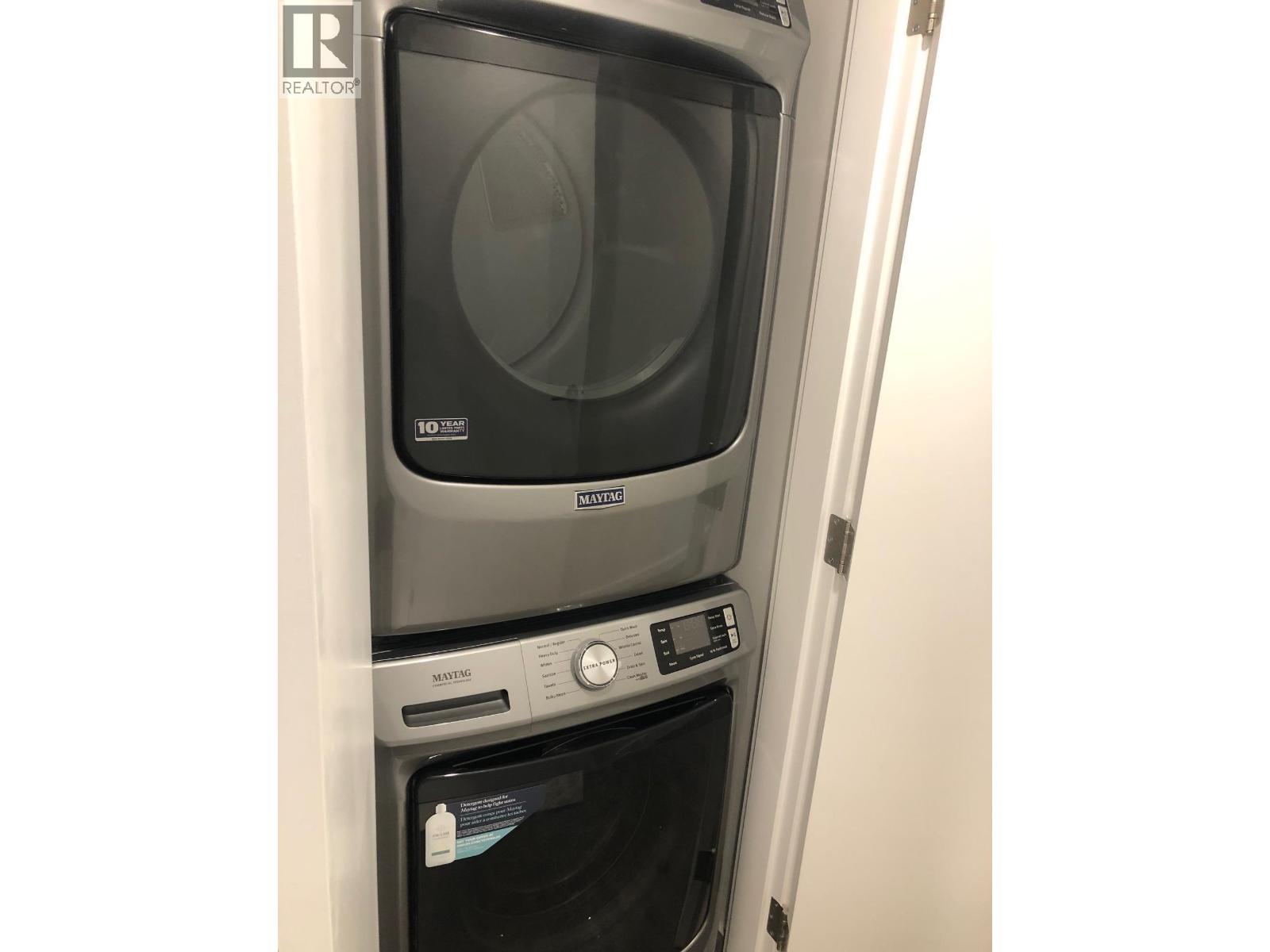A stacked washer and dryer in a small space.