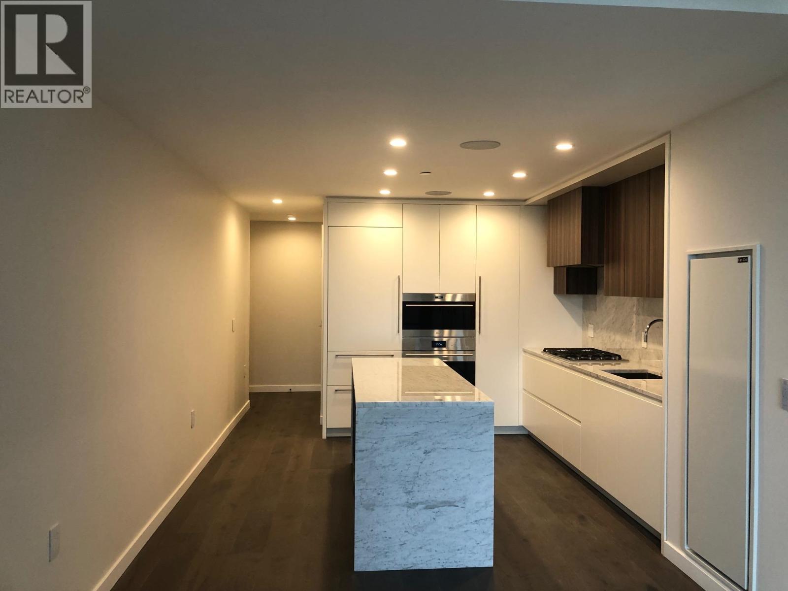 A modern kitchen with a marble island in the middle.