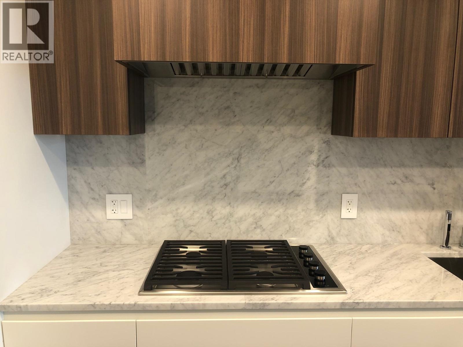 A kitchen counter with a stove top in the middle.