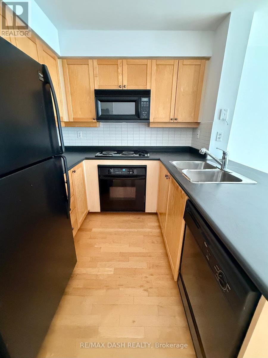 A kitchen with black appliances and wooden cabinets.