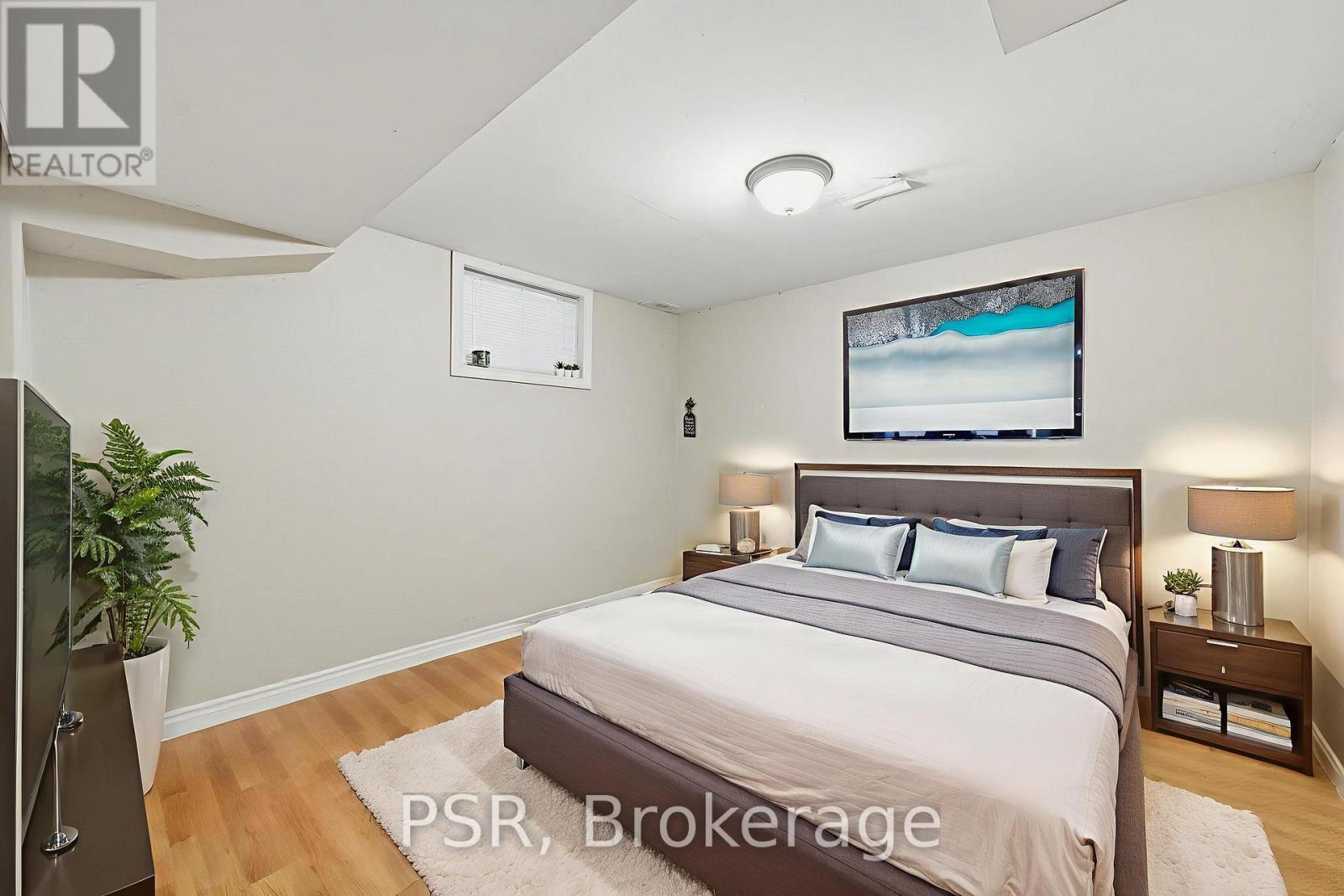 A bedroom with a large bed and a flat screen TV mounted on the wall.