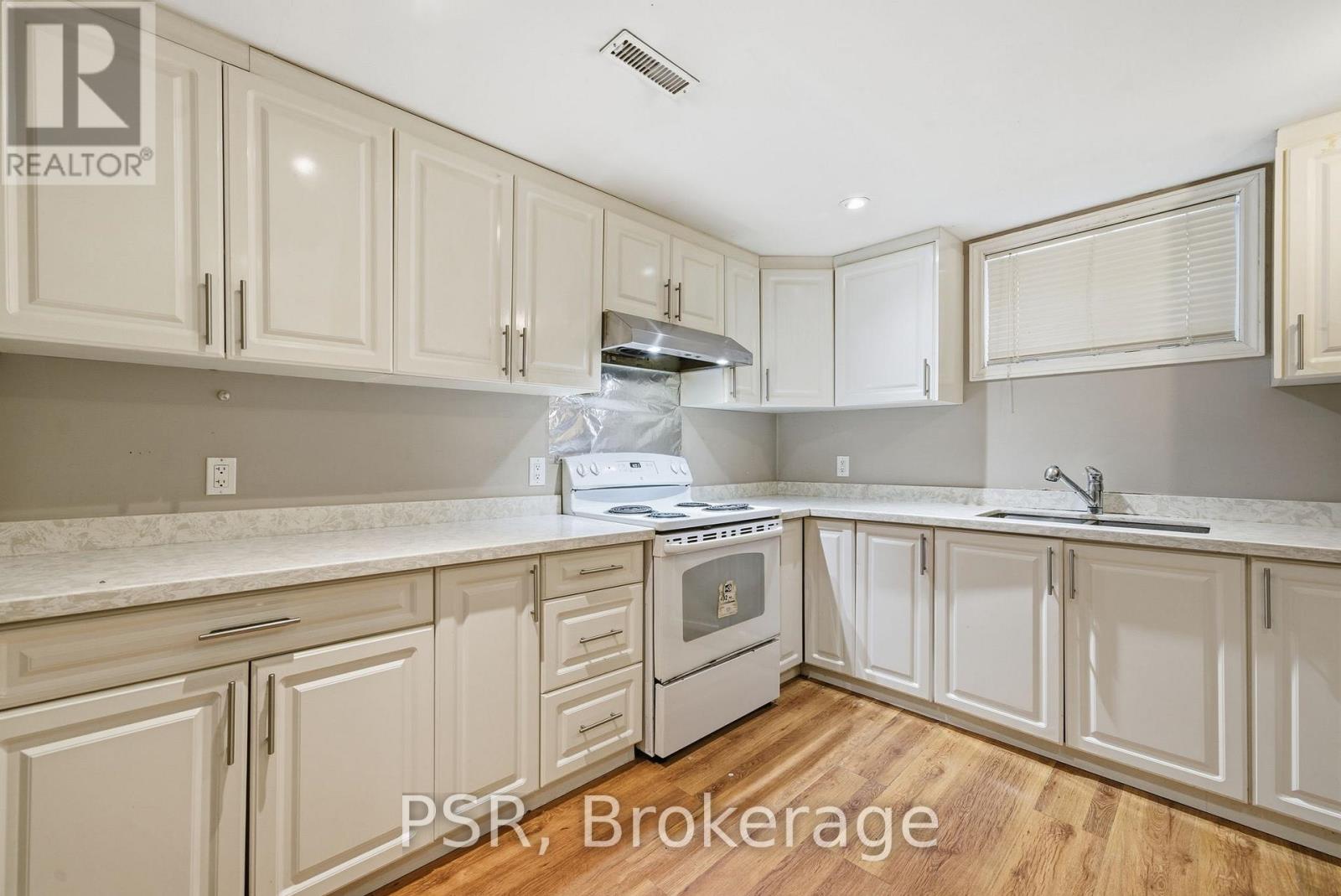 A kitchen with white cabinets and a stove top oven.