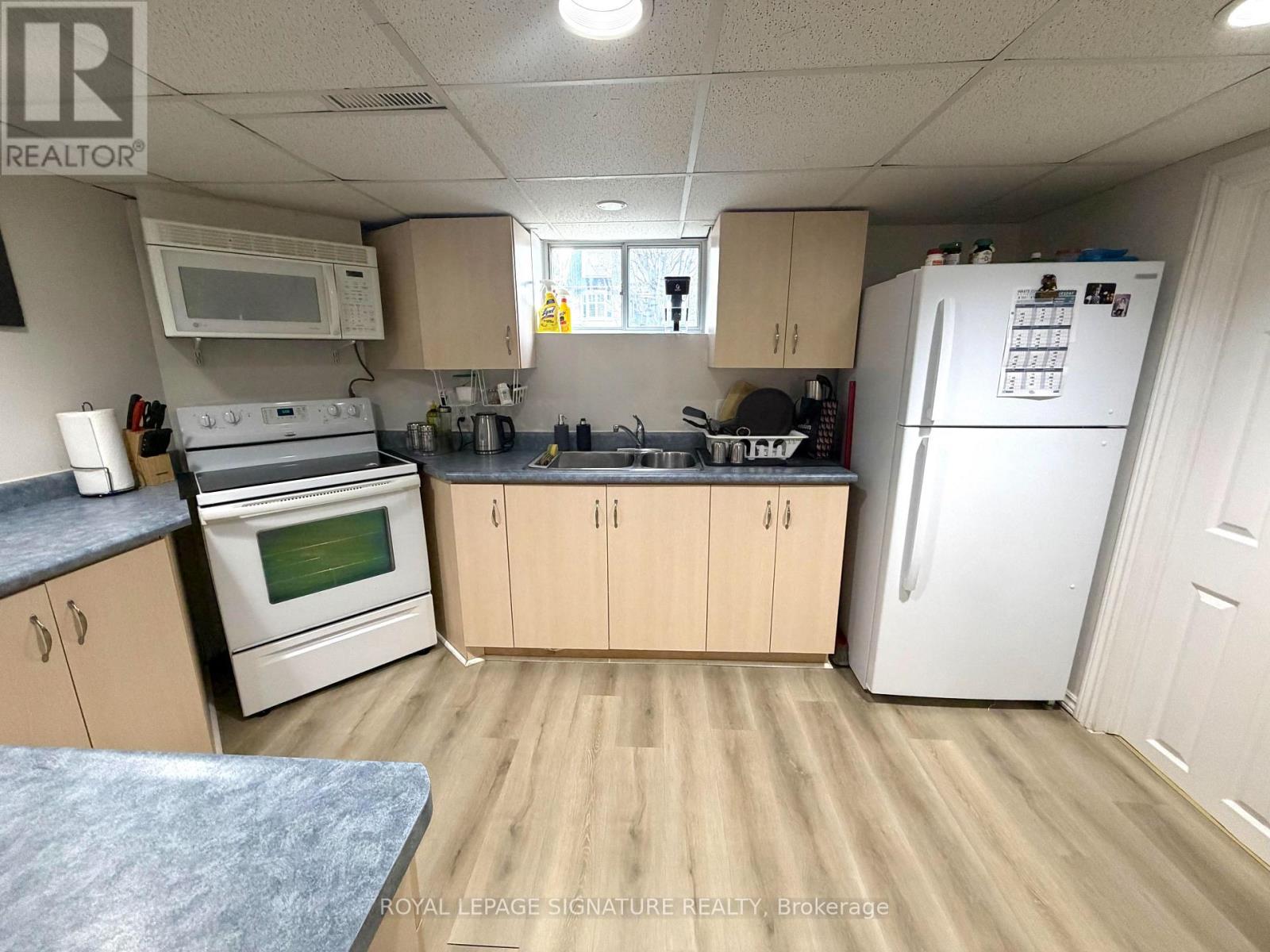 A kitchen with wooden cabinets and a white refrigerator.