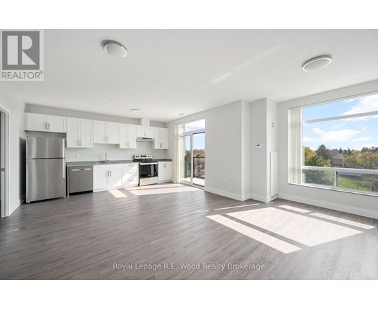 A spacious kitchen with white cabinets and a refrigerator.