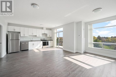 A spacious kitchen with white cabinets and a refrigerator.