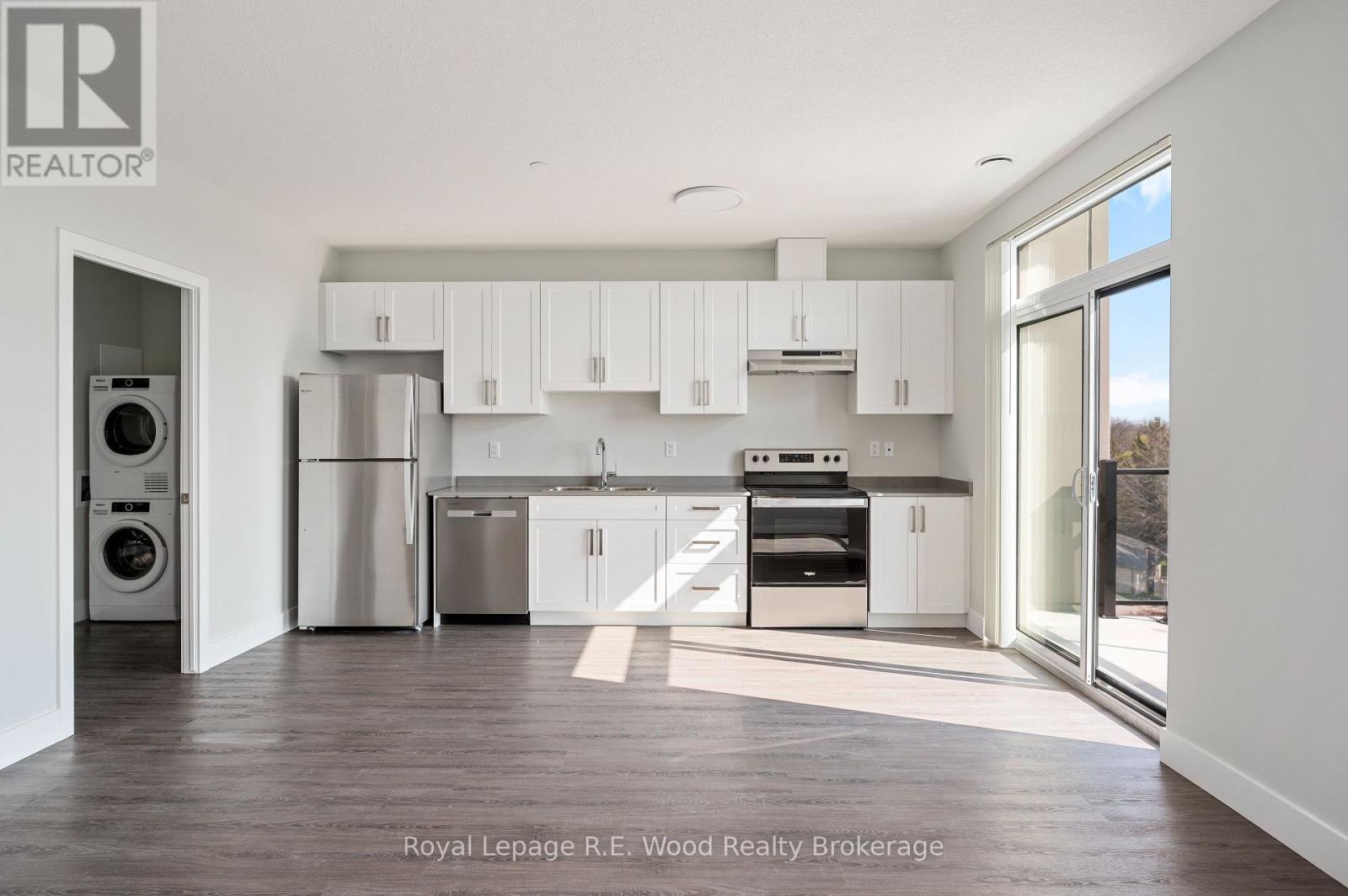 A modern kitchen with white cabinets and stainless steel appliances.