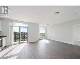 A spacious room with wooden flooring and a large window overlooking a balcony.