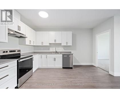 A white kitchen with a stove top oven and a dishwasher.